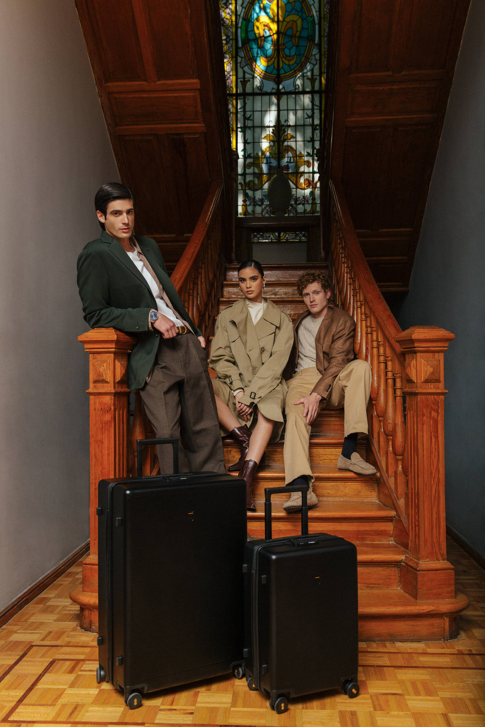 LEVEL8 Luminous 20" Carry-On and 28" Checked suitcases in Black held by three models.